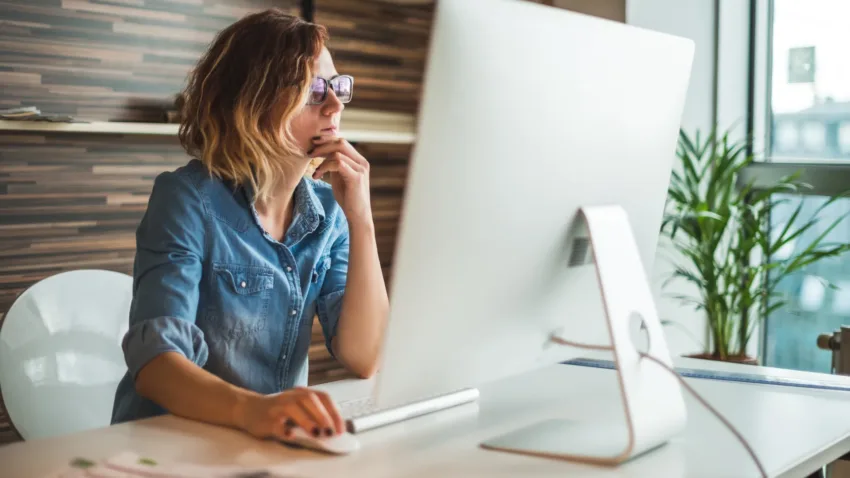 Women contemplating while looking at her computer