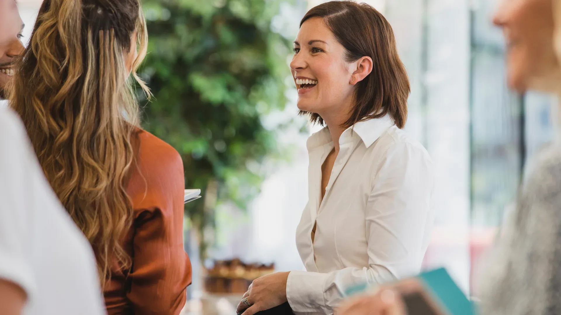 Woman smiling in the office speaking to a colleague