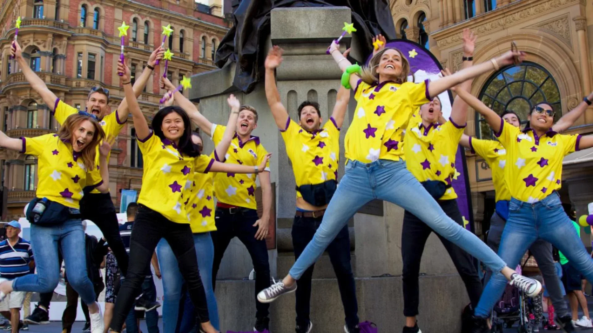 Starlight Children's Foundation volunteers jumping in the air with hands up