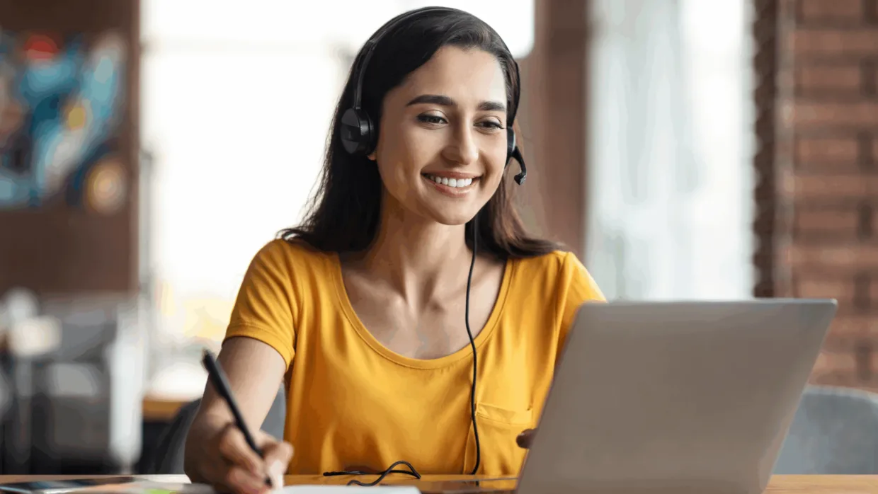 Happy female at laptop with headset on