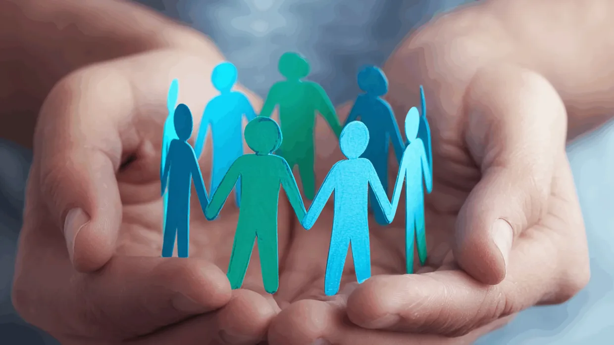 Hands holding paper cutouts of people