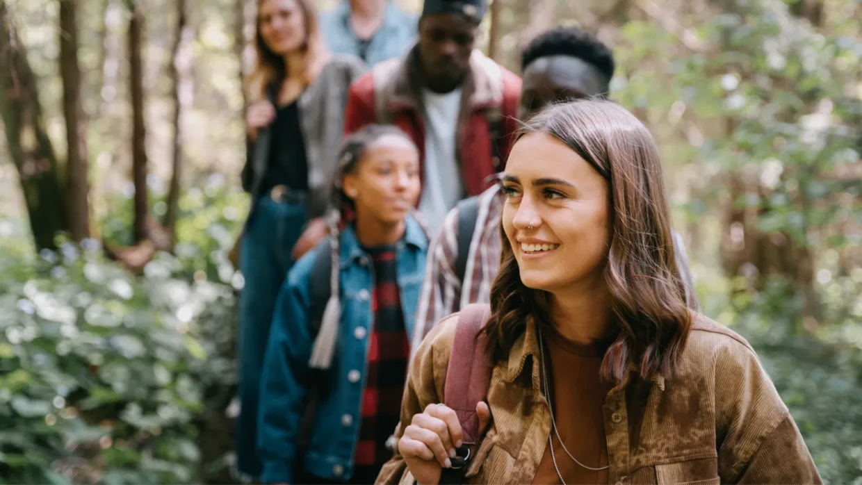 Young people in nature smiling on a hike