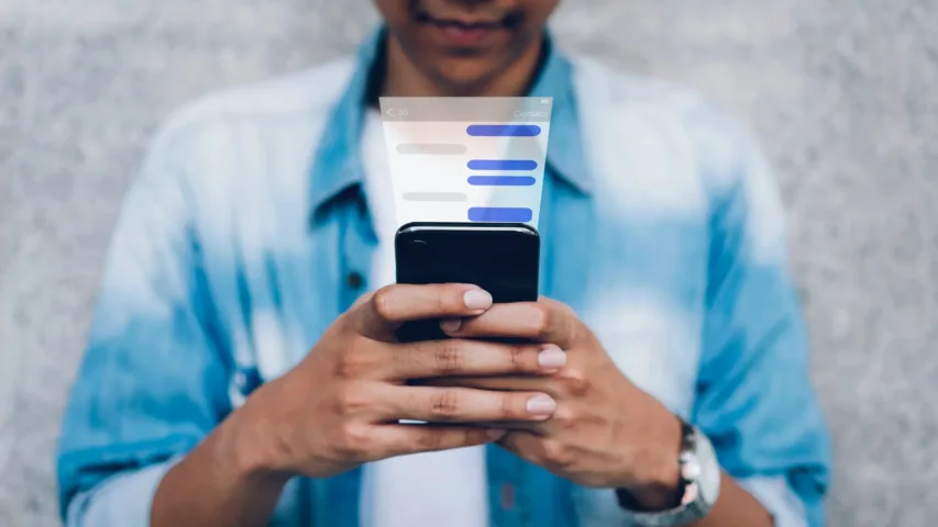 Man looking at mobile phone from face down - can see a reflection of chat history