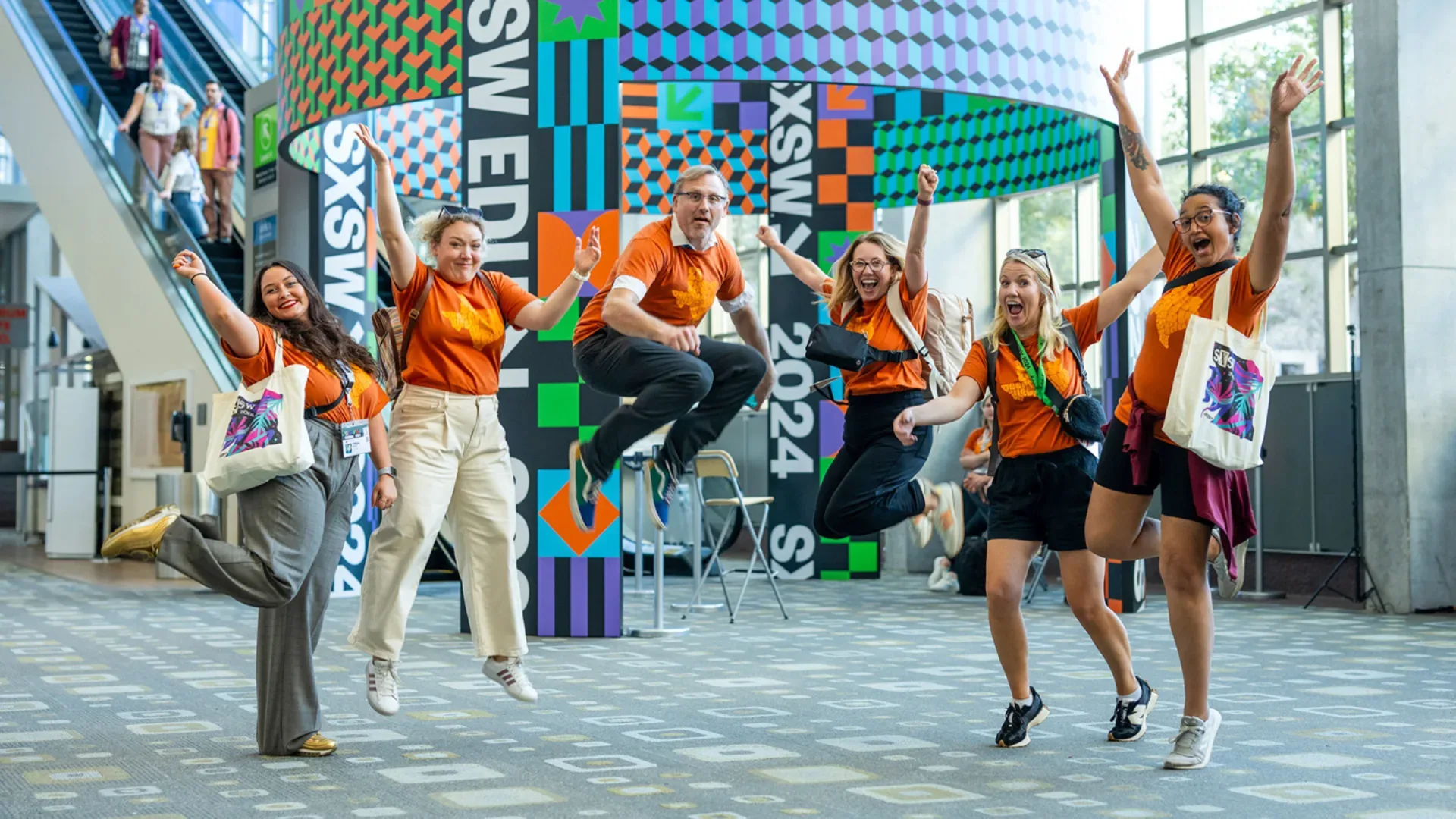 Group of SXSW volunteers jumping for joy in the air onsite