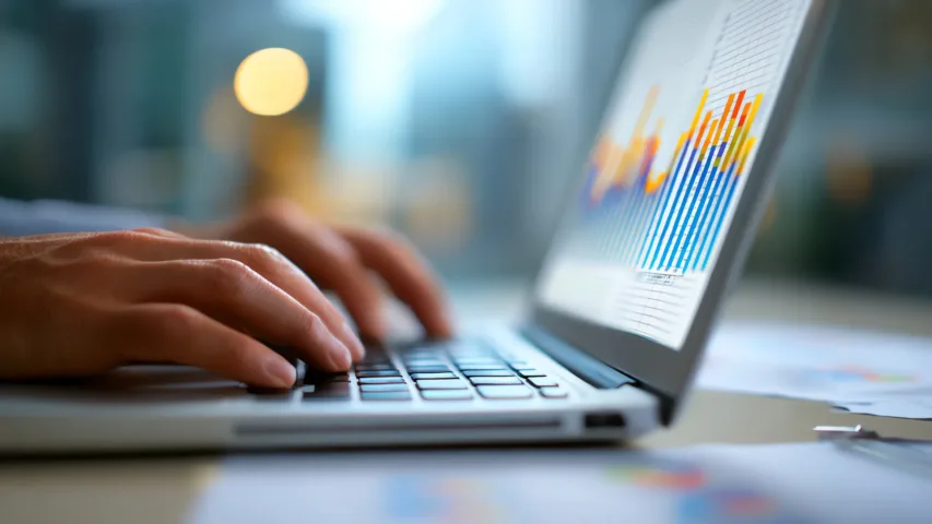 Picture of someone typing on the laptop (can just see hands) with dashboard on screen