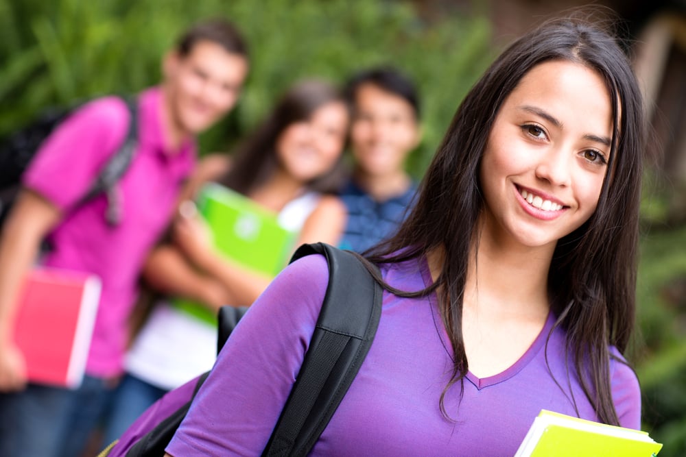 Female student smiling at the university holding notebook