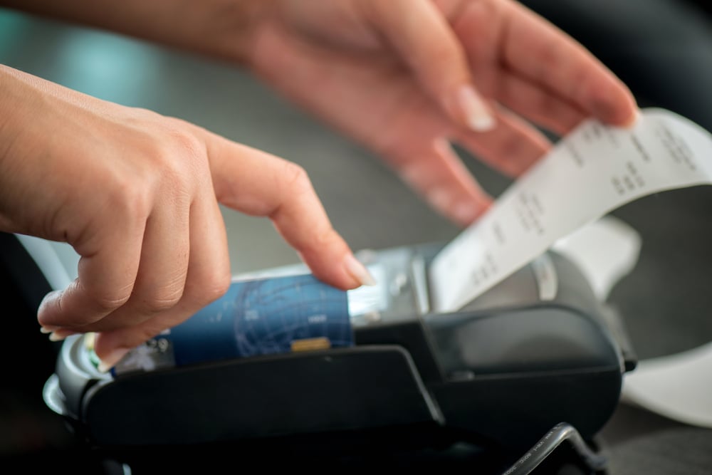 Hand taking receipt from pos terminal-1