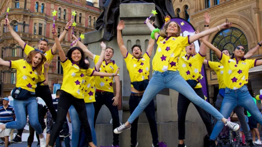 Starlight Children's Foundation volunteers jumping in the air with hands up