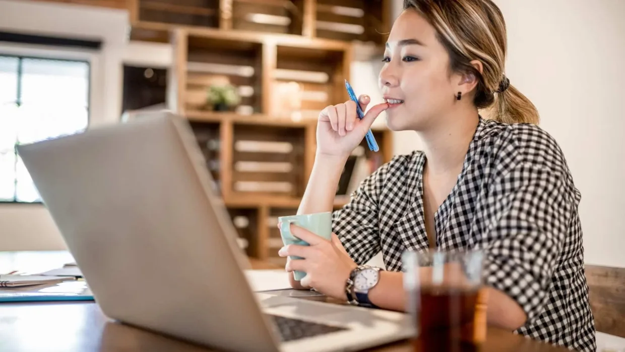 Woman working from the office looking at her laptop