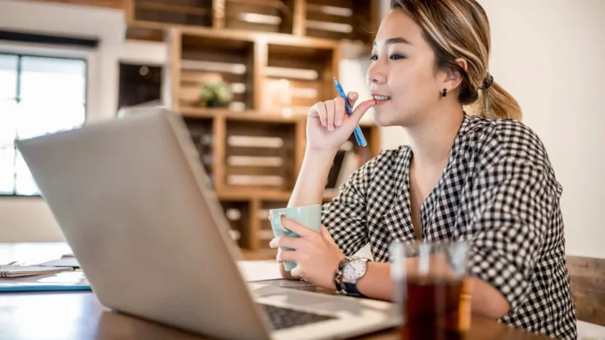 Woman working from the office looking at her laptop