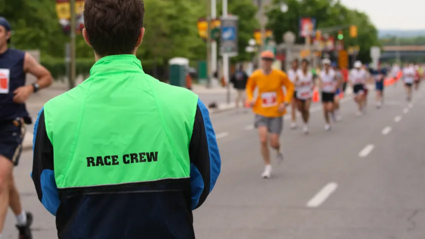 A race crew volunteer in high vis at a running race