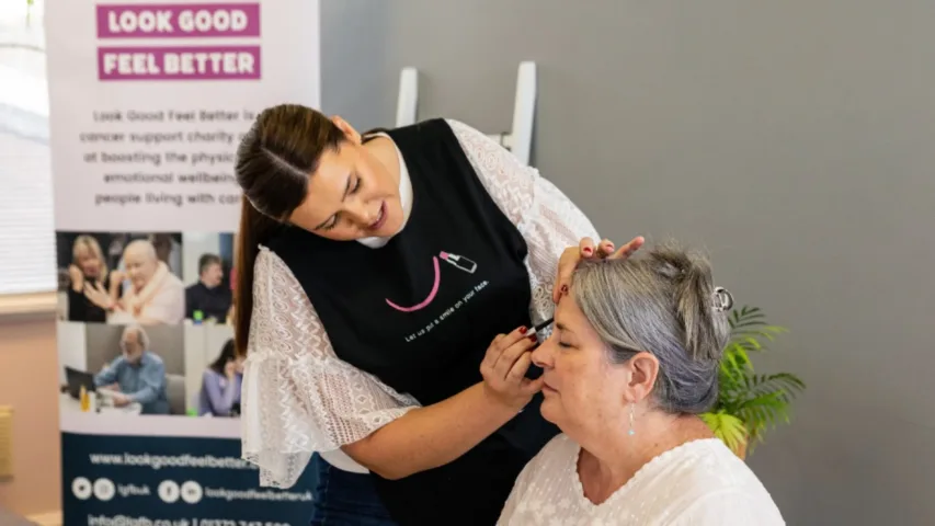 Woman applying make up in a Look Good Feel Better charity workshop
