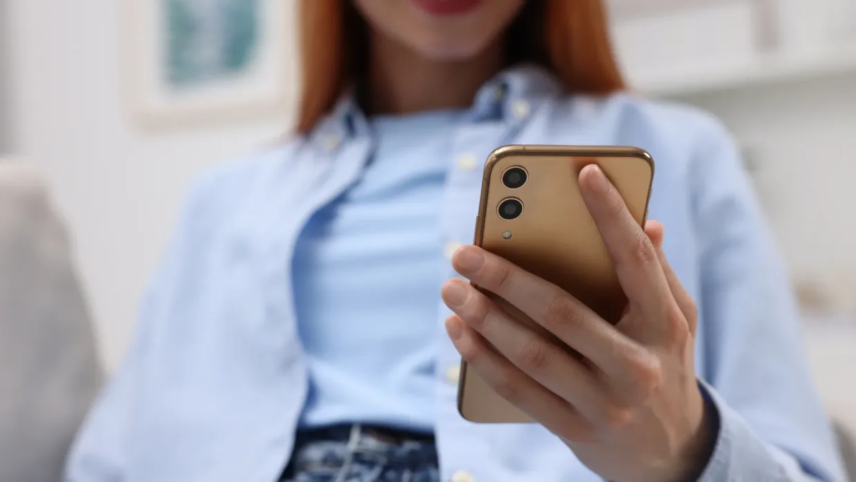 Woman from mouth down looking at something on her phone