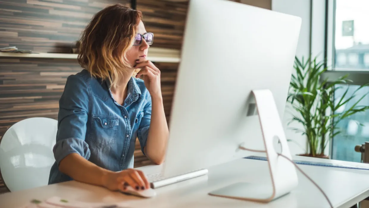 Women contemplating while looking at her computer