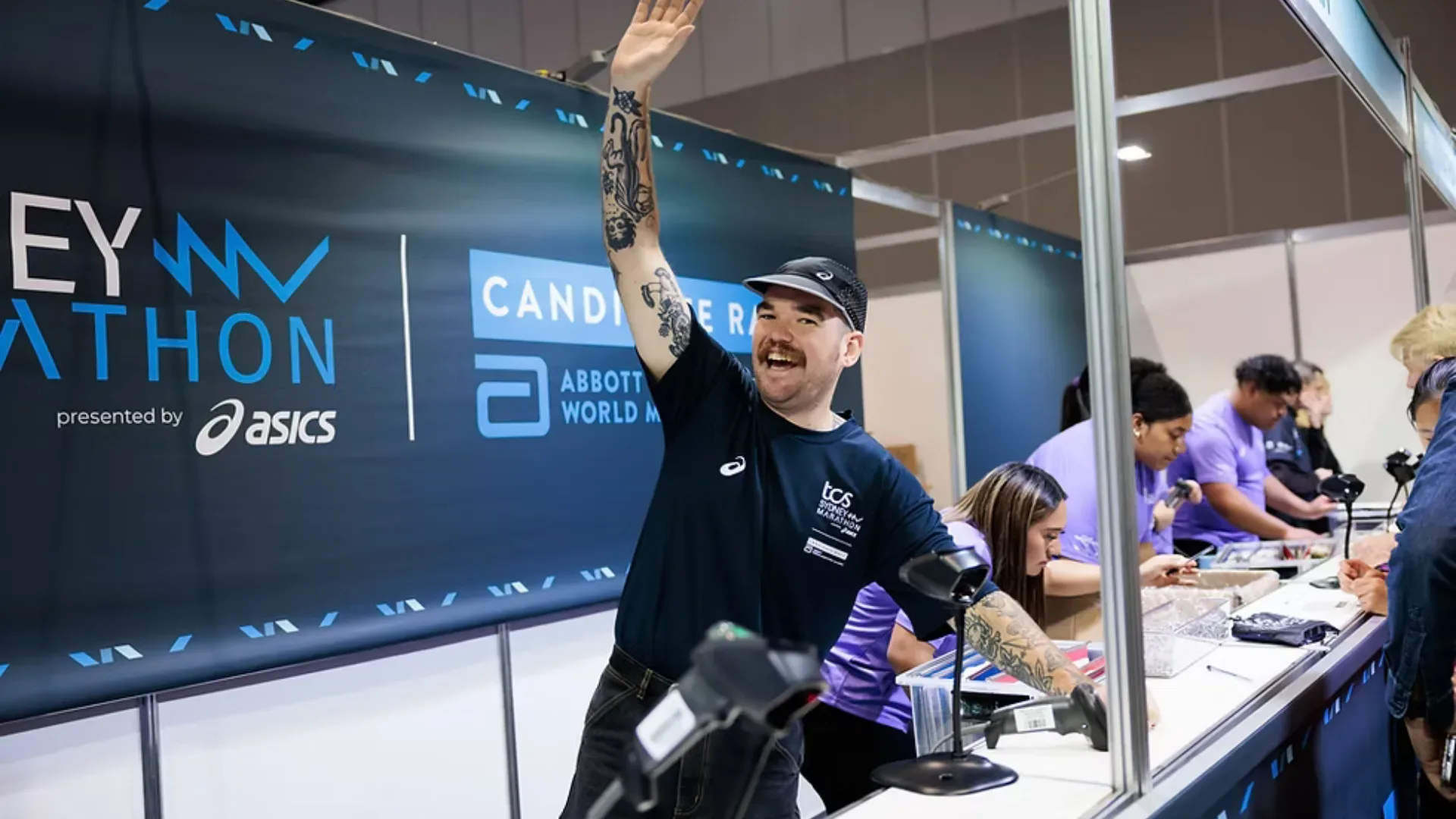 Volunteer smiling happily and waving at an event