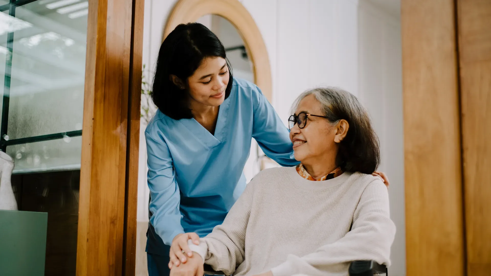 Woman helping lady in a wheelchair