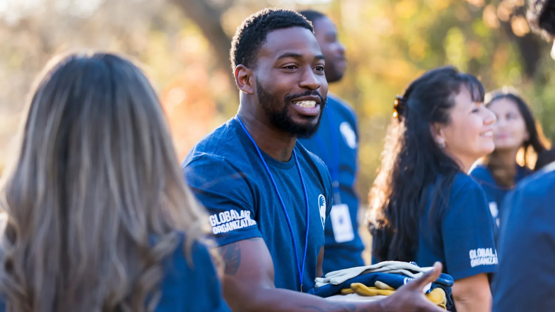 Volunteer smiling with clipboard in the park