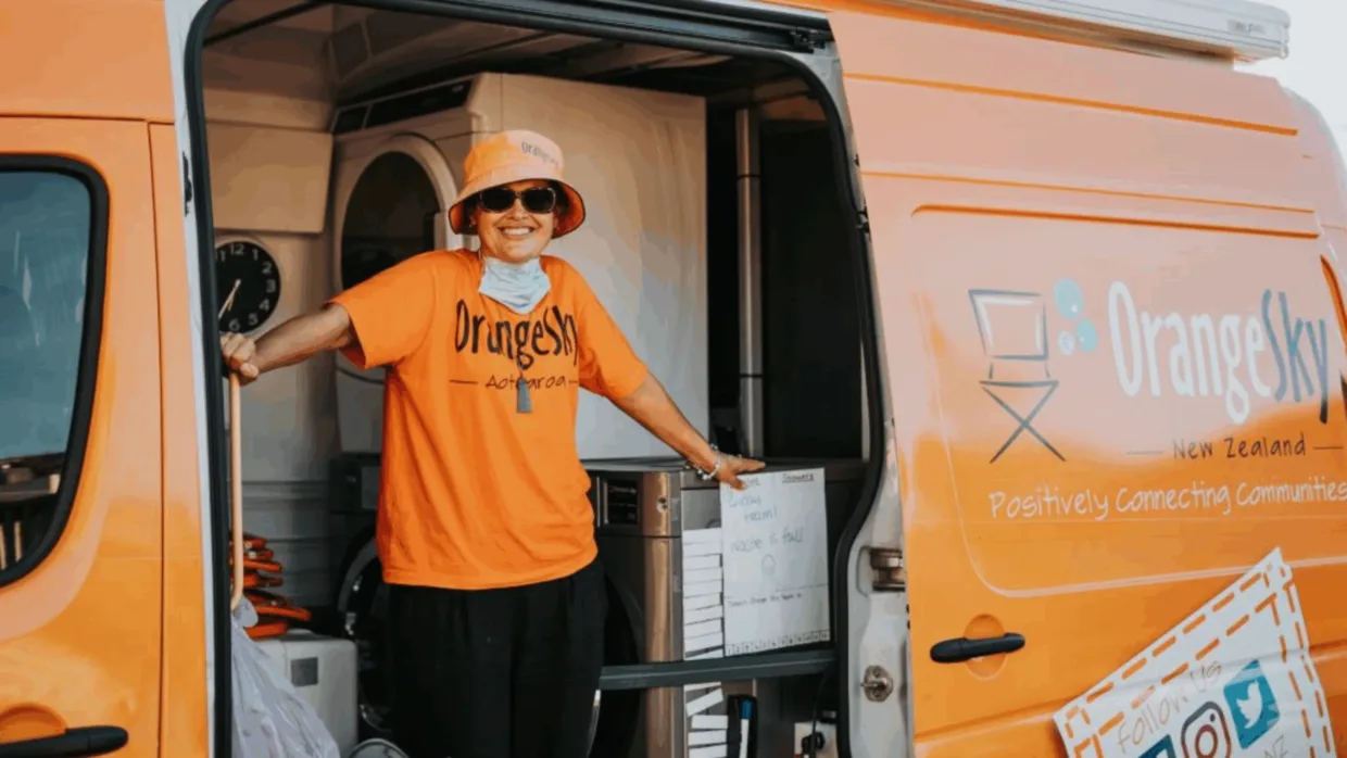 Orange Sky volunteer smiling in front of a van