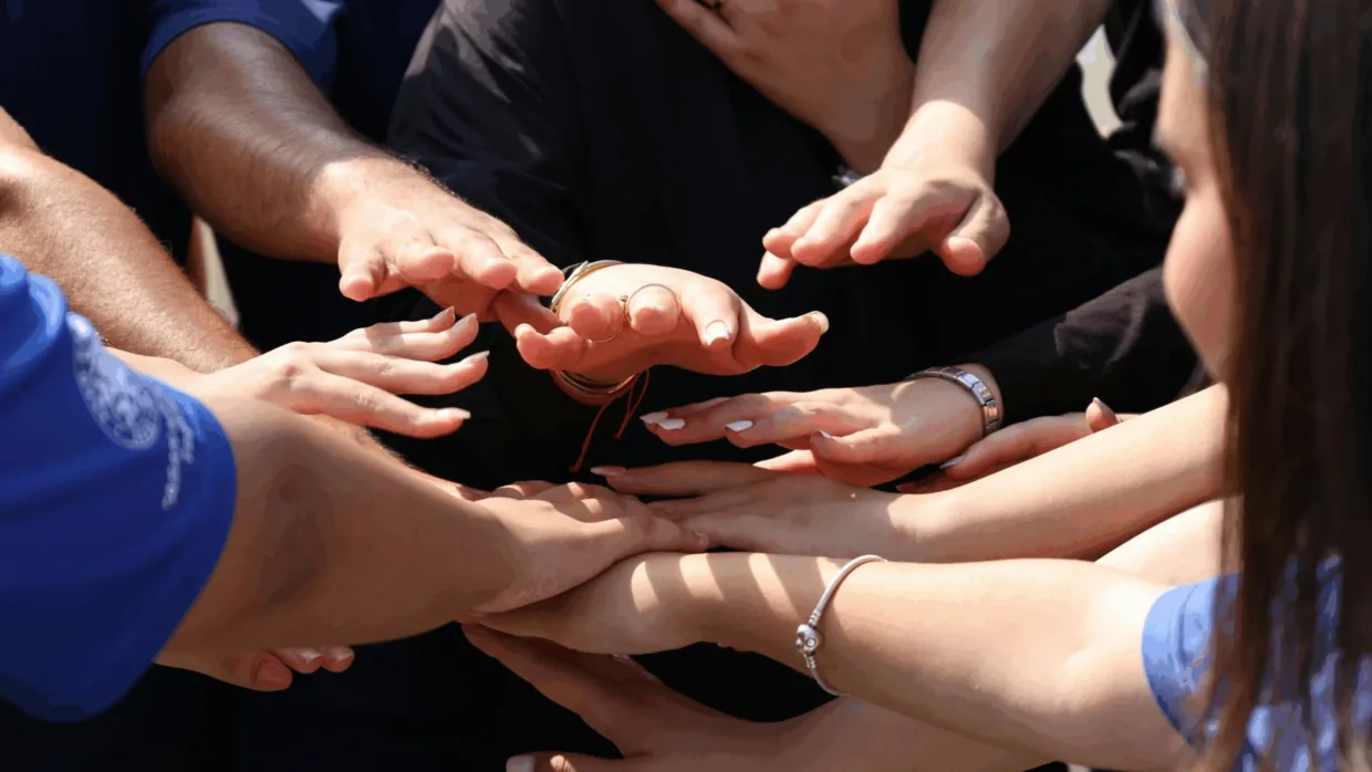 Circle of people with hands in the middle