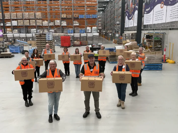 Foodbank Victoria volunteers holding boxes in a warehouse