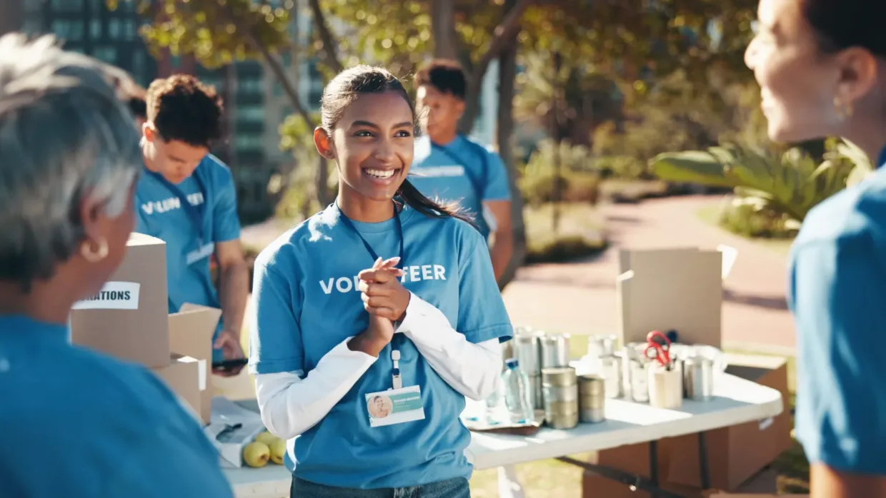 Volunteer out in a park smiling with her hands clapped together