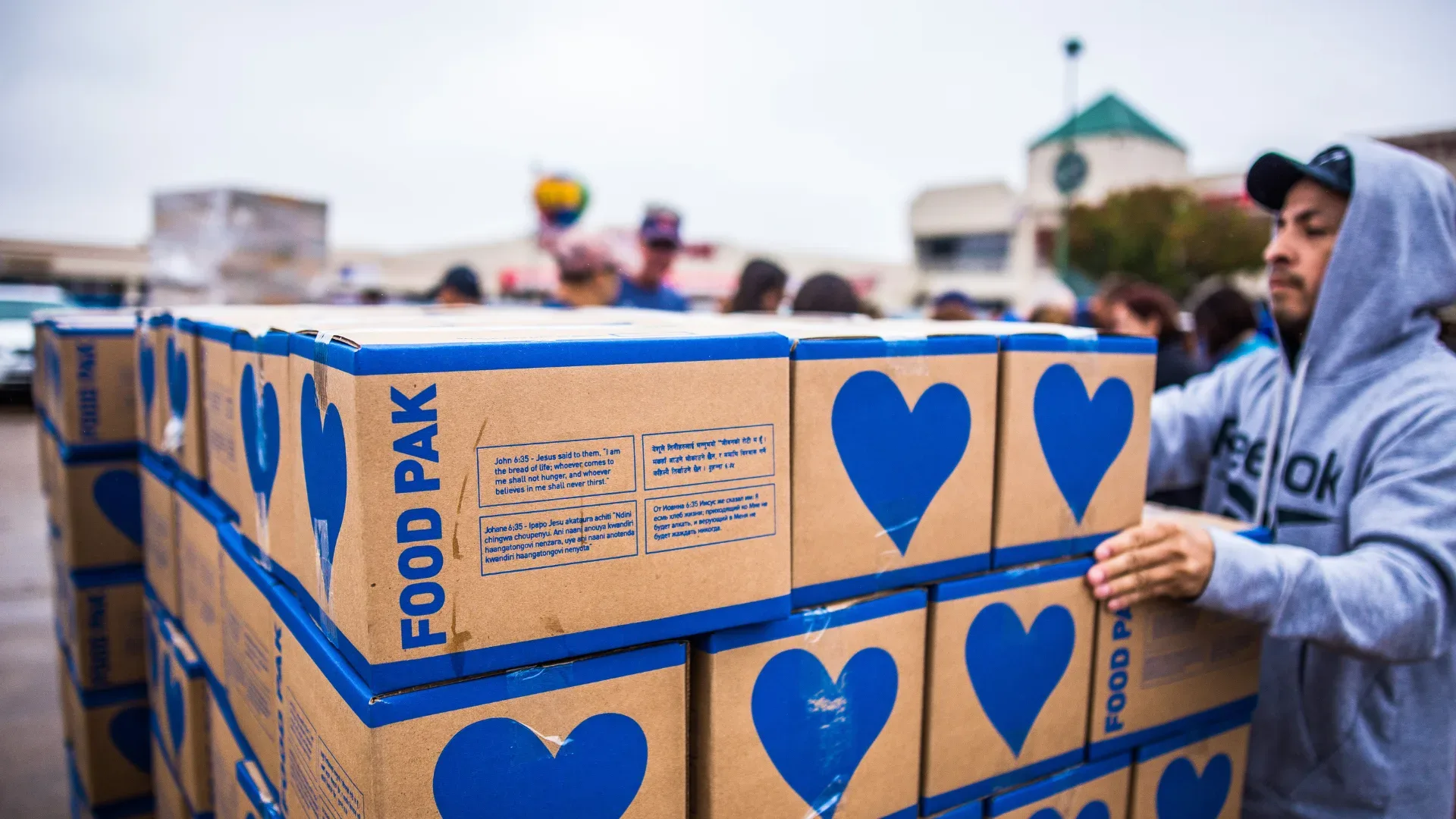 Volunteer working in food relief helping to package a large amount of boxes