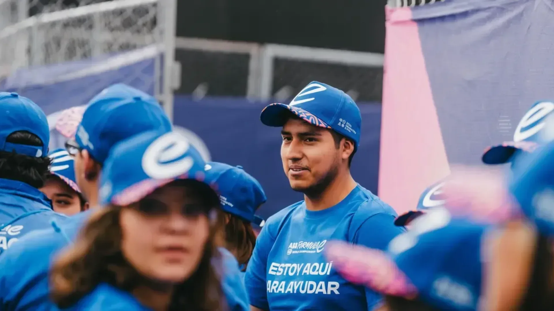 Formula E volunteers dressed in blue uniforms onsite at an event