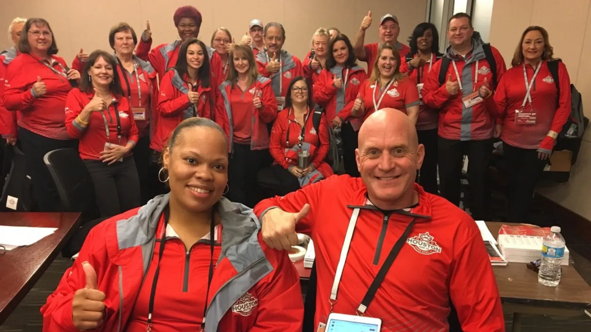 Picture of a group of Houston Super Bowl Volunteers smiling at camera in their red uniforms