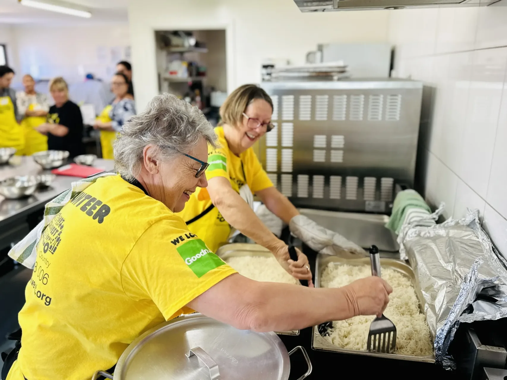 OzHarvest volunteers in a commercial kitchen preparing meals for the community