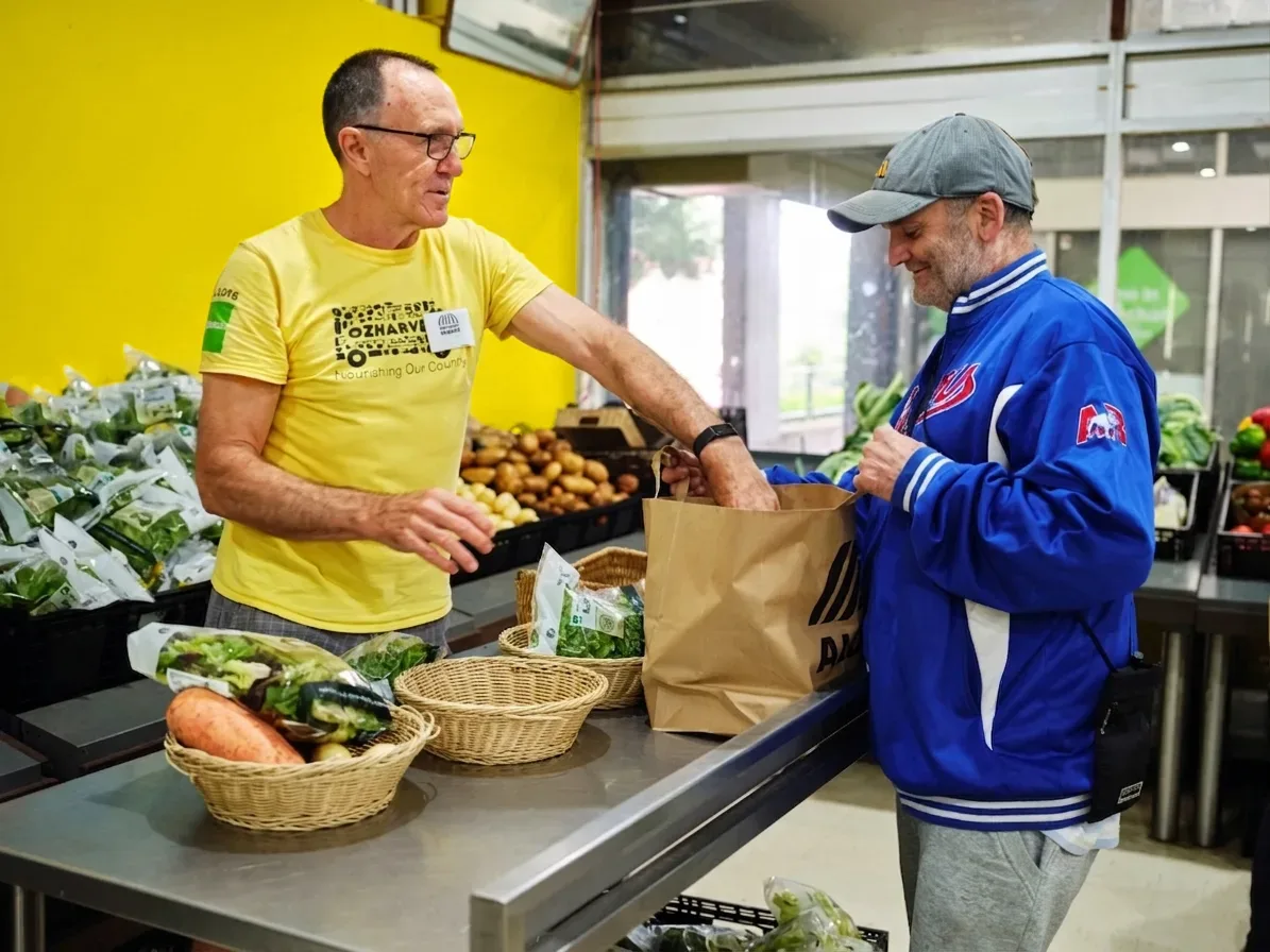 OzHarvest volunteer at Waterloo Market distributing food to the community